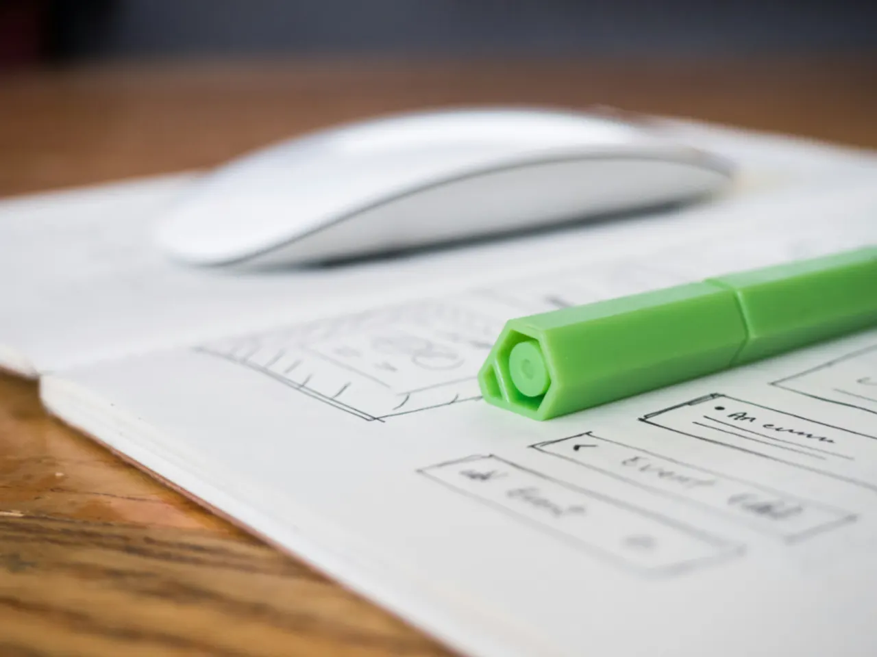 Website wireframe sketchpad with pen and mouse on a desk
